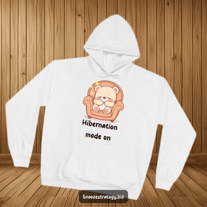 Funny hoodie featuring a peaceful bear cub character fast asleep in a soft armchair, emitting gentle snores.